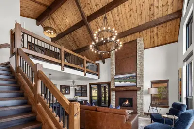 a living room with a staircase and a fireplace at Anglers Paradise - Located on Lake Estes, Fireplace, Two Large Patios, and Private Jacuzzi in Estes Park