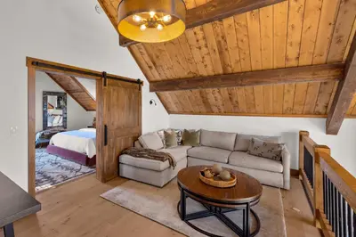 a living room with a couch and a table at Anglers Paradise - Located on Lake Estes, Fireplace, Two Large Patios, and Private Jacuzzi in Estes Park