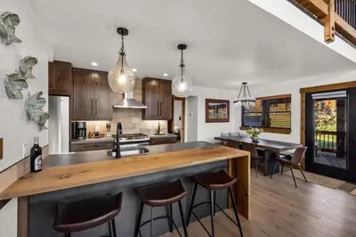 an open kitchen with a large island with bar stools at Anglers Paradise - Located on Lake Estes, Fireplace, Two Large Patios, and Private Jacuzzi in Estes Park