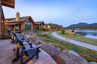 a row of benches sitting in front of a lodge at Anglers Paradise - Located on Lake Estes, Fireplace, Two Large Patios, and Private Jacuzzi in Estes Park