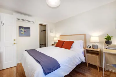 a bedroom with a large white bed and a desk at Boulder Guest House in Boulder