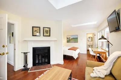 a living room with a fireplace and a bed at Boulder Guest House in Boulder