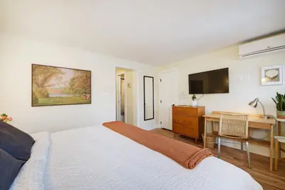 a bedroom with a bed and a desk and a television at Boulder Guest House in Boulder