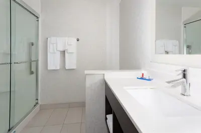 a white bathroom with a sink and a shower at Holiday Inn Express & Suites - Firestone - Longmont by IHG in Longmont