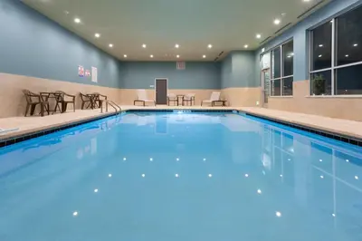a pool with blue water in a hotel room at Holiday Inn Express & Suites - Firestone - Longmont by IHG in Longmont