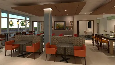 a lobby with tables and chairs in a restaurant at Holiday Inn Express & Suites - Firestone - Longmont by IHG in Longmont
