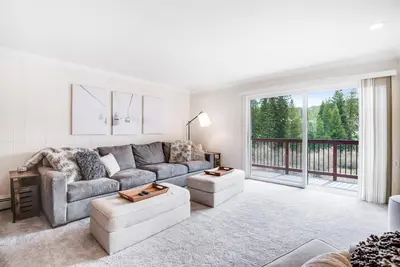 a living room with a couch and a large window at Modern High Country Haus in Winter Park