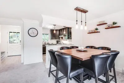 a kitchen and dining room with a wooden table and black chairs at Modern High Country Haus in Winter Park