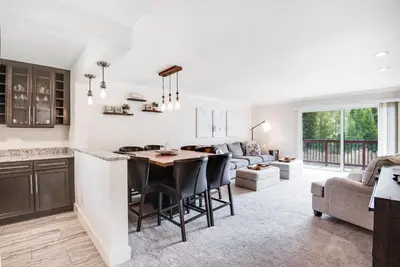 a kitchen and living room with a table and a couch at Modern High Country Haus in Winter Park