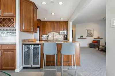 a kitchen with wooden cabinets and blue bar stools at Lake Cliffe E-305 - Dillon in Dillon