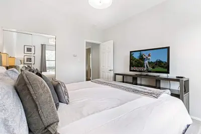 a white bedroom with a large bed and a flat screen tv at Lake Cliffe E-305 - Dillon in Dillon