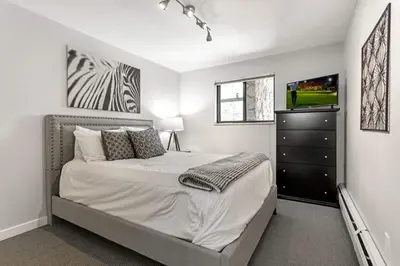 a bedroom with a bed with a dresser and a television at Lake Cliffe E-305 - Dillon in Dillon