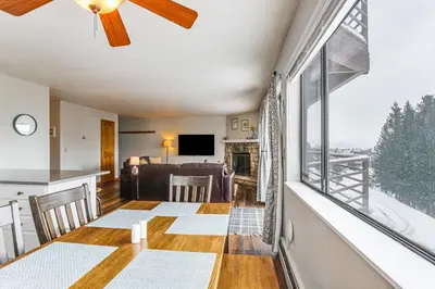 a living room with a table and a large window at 11 Mi to Keystone Resort Condo in Silverthorne in Silverthorne