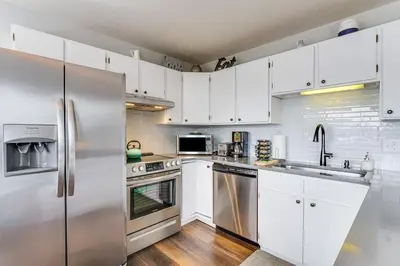a kitchen with white cabinets and a stainless steel refrigerator at 11 Mi to Keystone Resort Condo in Silverthorne in Silverthorne