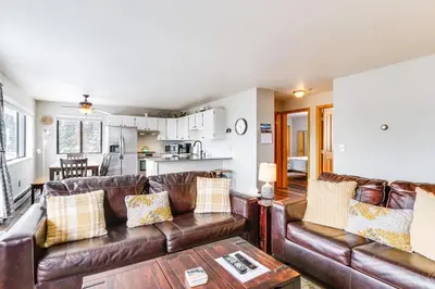 a living room with a leather couch and a table at 11 Mi to Keystone Resort Condo in Silverthorne in Silverthorne