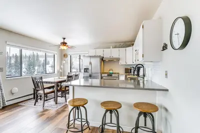 a kitchen and dining room with a counter and stools at 11 Mi to Keystone Resort Condo in Silverthorne in Silverthorne