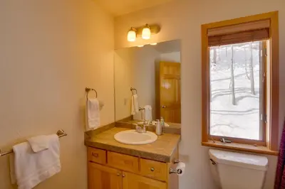 a bathroom with a sink and a toilet and a mirror at Slopeside Sanctuary - Penthouse Less Than 1 Mi to Lifts! in Winter Park