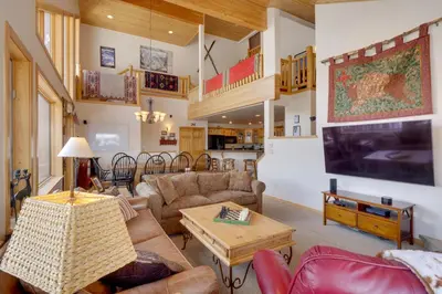a living room with couches and a large tv at Slopeside Sanctuary - Penthouse Less Than 1 Mi to Lifts! in Winter Park
