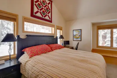 a bedroom with a large bed and two windows at Slopeside Sanctuary - Penthouse Less Than 1 Mi to Lifts! in Winter Park