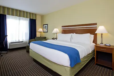 a hotel room with a large bed and a window at Holiday Inn Express and Suites Denver East Peoria Street by IHG in Denver