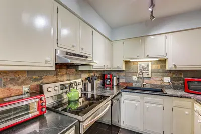 a kitchen with white cabinets and white appliances at 3 Mi to Winter Park Resort Cozy Ski Condo in Winter Park