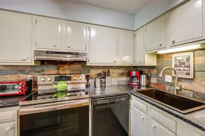 a kitchen with white cabinets and a sink at 3 Mi to Winter Park Resort Cozy Ski Condo in Winter Park