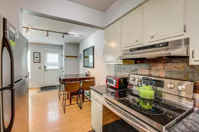 a kitchen with white cabinets and a stove top oven at 3 Mi to Winter Park Resort Cozy Ski Condo in Winter Park