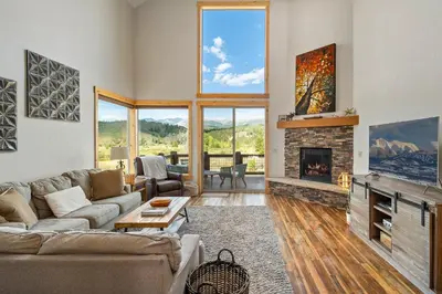a living room with a couch and a fireplace at Mountain Willow at Grand Park home in Fraser