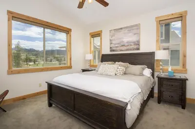 a bedroom with a large bed and two windows at Mountain Willow at Grand Park home in Fraser