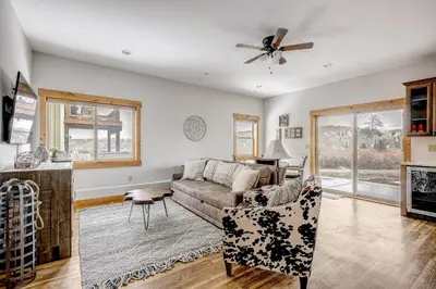 a living room with a couch and a ceiling fan at Mountain Willow at Grand Park home in Fraser