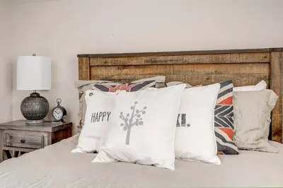 a bed with pillows with a happy birthday pillow on it at Mountain Willow at Grand Park home in Fraser