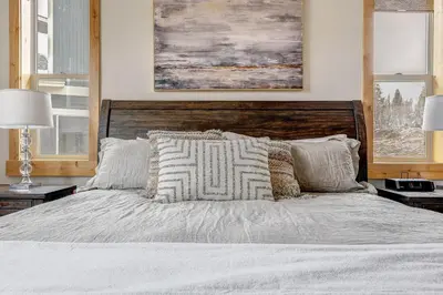 a bedroom with a large white bed with pillows at Mountain Willow at Grand Park home in Fraser