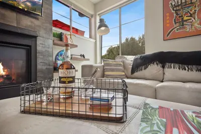 a living room with a couch and a fireplace at Swanky Townhome near Old Town, Breweries & River! in Fort Collins