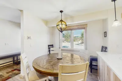 a dining room with a wooden table and chairs at Modern Fraser Mountain Home in Fraser