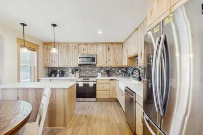 a kitchen with wooden cabinets and a stainless steel refrigerator at Modern Fraser Mountain Home in Fraser
