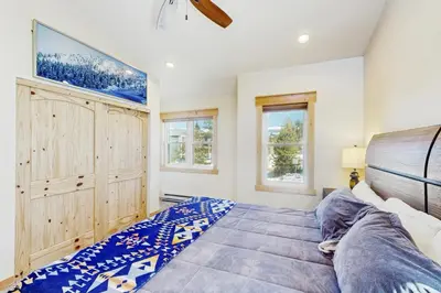 a bedroom with a bed and two windows at Modern Fraser Mountain Home in Fraser