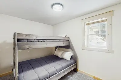 a bunk bed in a room with a window at Modern Fraser Mountain Home in Fraser