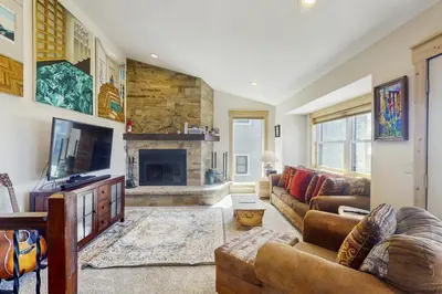 a living room with a couch and a fireplace at Modern Fraser Mountain Home in Fraser