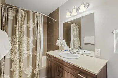 a bathroom with a sink and a shower curtain at Royal Rays in Frisco
