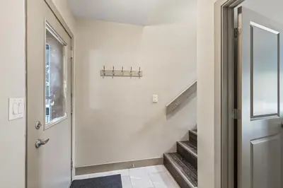 a hallway with a door and stairs with a window at Royal Rays in Frisco