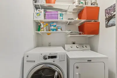 a laundry room with a washing machine and shelves at Royal Rays in Frisco