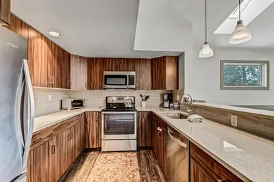 a kitchen with wooden cabinets and stainless steel appliances at Royal Rays in Frisco
