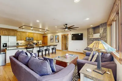 a living room with two couches and a kitchen at Mountain Retreat on 1st in Frisco