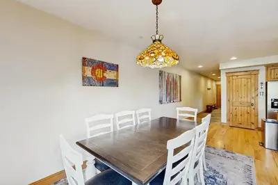 a dining room with a wooden table and white chairs at Mountain Retreat on 1st in Frisco