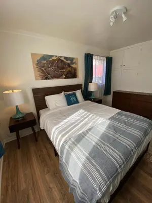 a bedroom with a bed with a blue and white comforter at A-Lodge Lyons in Lyons