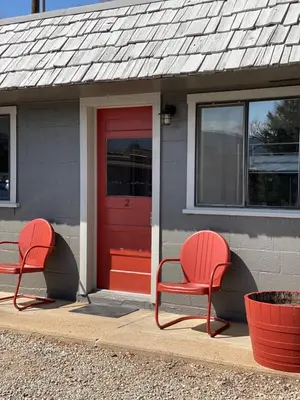 two red chairs sitting in front of a red door at A-Lodge Lyons in Lyons