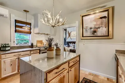a kitchen with a large marble counter top and a chandelier at A-Lodge Lyons in Lyons