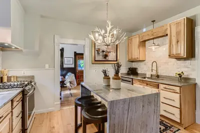 a kitchen with wooden cabinets and a large island with bar stools at A-Lodge Lyons in Lyons