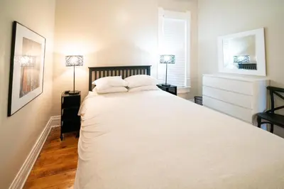 a bedroom with a large white bed with two lamps at 2360 Glenarm Place in Denver