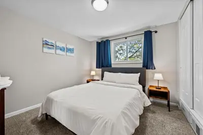 a bedroom with a large white bed with blue curtains at 5632 Field St in Arvada